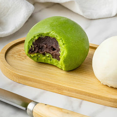 Green dumpling with a chocolate filling on a wooden board
