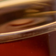 Close-up of a red container with a gold lid, blurred and out of focus.