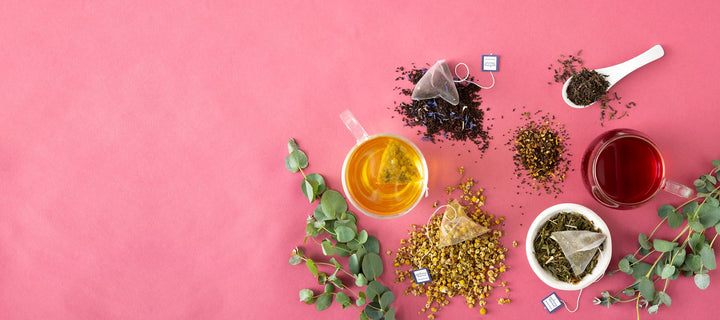 Organic tea sachets on pink surface